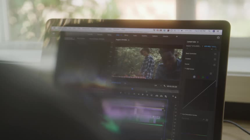 Laptop screen shows a video editing software with a scene being adjusted on the timeline