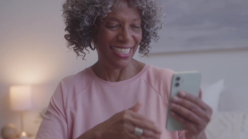 Woman smiles and waves during a video call on her phone