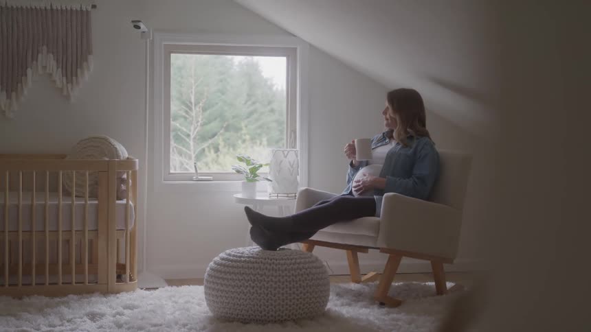 A pregnant woman enjoys coffee at home and touching her belly