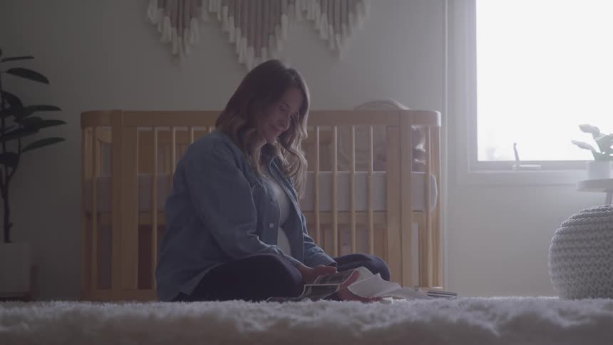 The woman looks at a sonogram print out at home