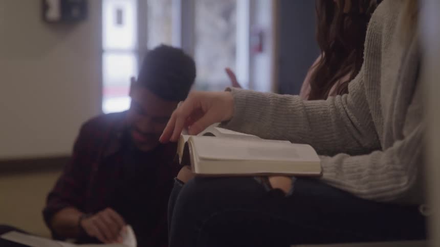 People read the bible while sitting in an indoor setting
