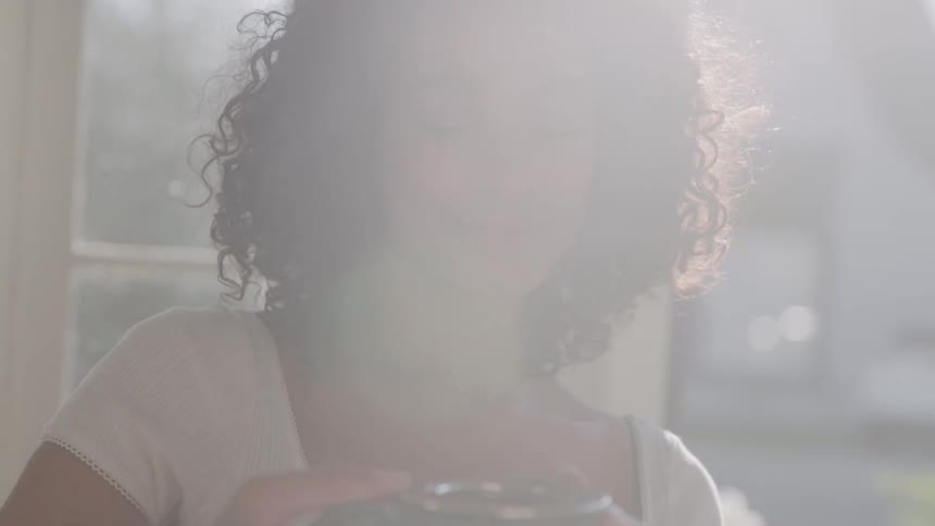 A woman smiles gently in bright natural light