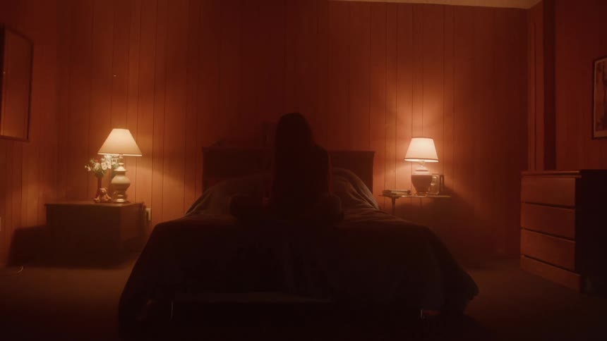 The person is covered in shadows on the bed