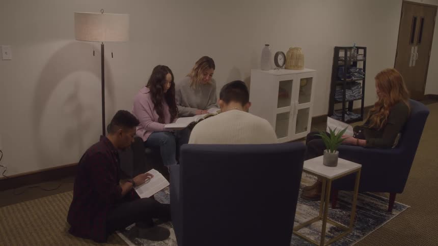 A group of friends reads books together indoors