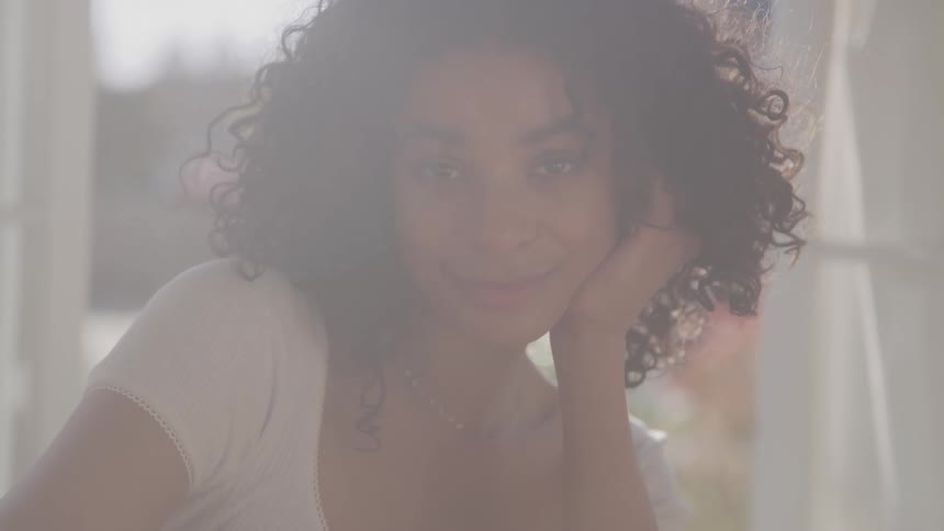 Close up portrait of a young black woman sitting indoors during daytime