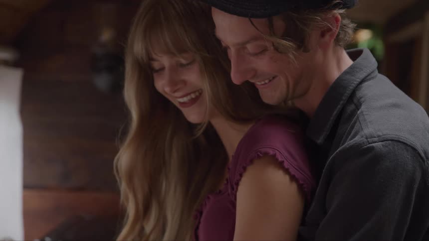 A couple smiling and embracing each other warmly indoors
