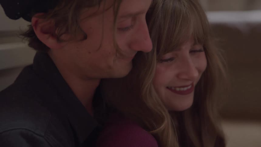 A man and a woman embrace and smile at each other