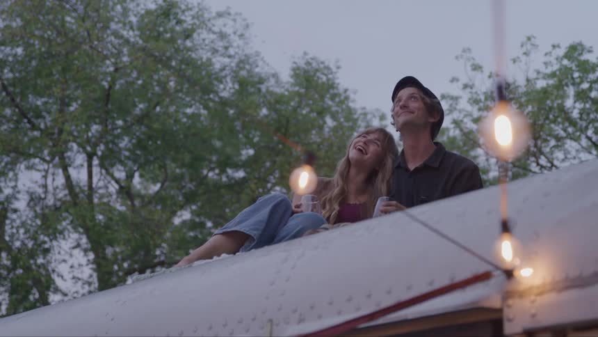 A couple enjoys a romantic rooftop date with wine