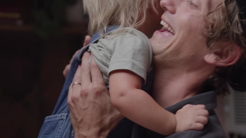 A little boy happily gives his father a hug as they both smile