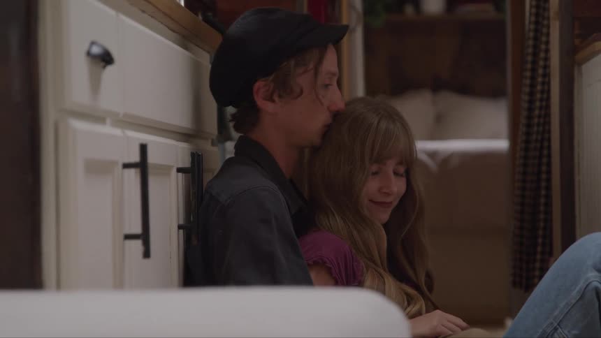 Couple sitting on the floor shares a moment of affection and smiles