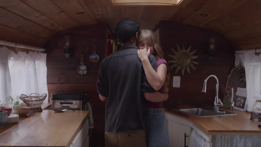 Young couple slowdance in a cozy woodlined kitchen