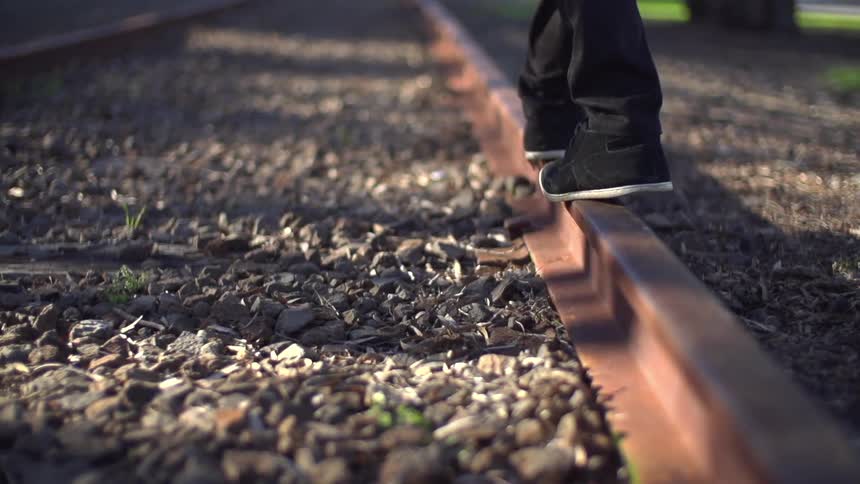 Person walking over the rail of a train track