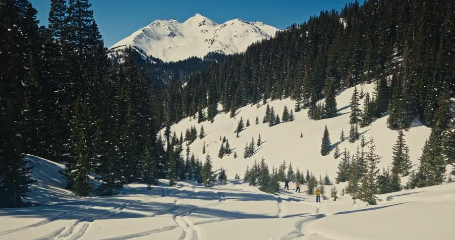 Some people walking through a snowy mountain landscape