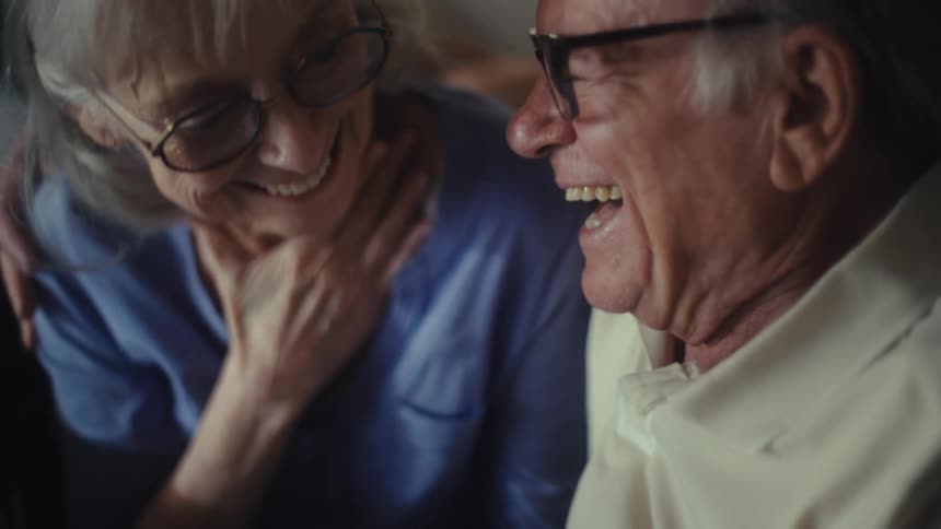 A man and woman seem relieved as they look at a calculator