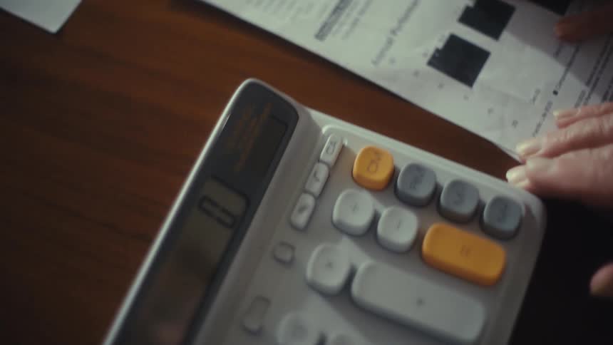 The man is typing into the calculator