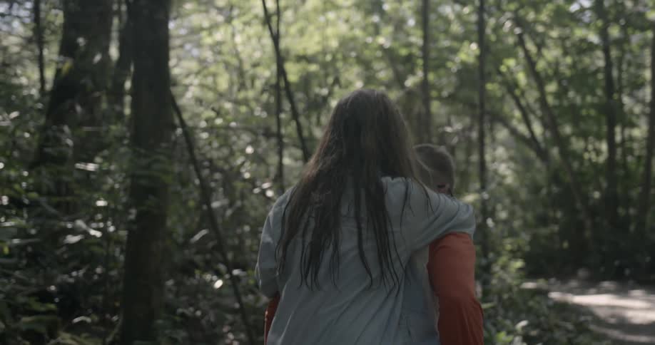 A woman is getting a piggyback ride in the woods