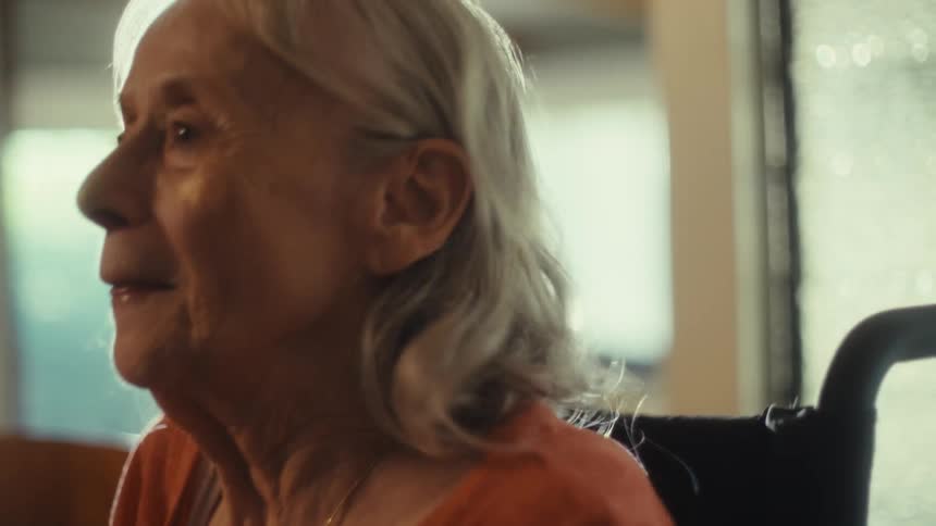 Excited elderly woman talks into a microphone while at home on a sunny day