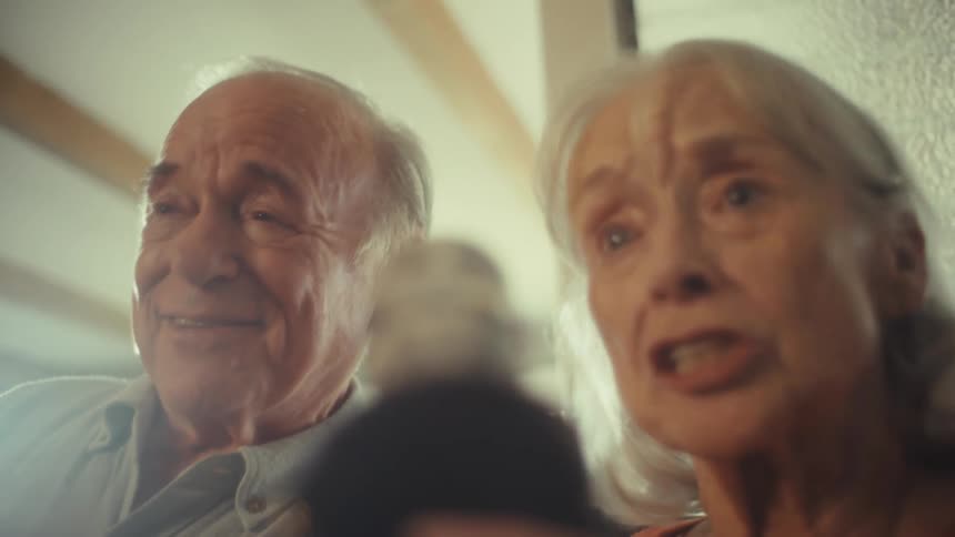 The man and woman sing with a microphone and nod their heads