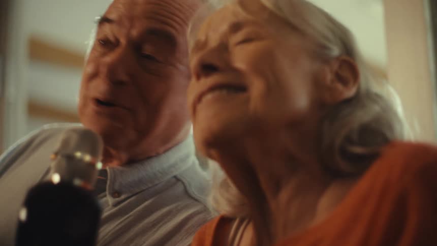 Couple sings cheerfully in front of the microphone