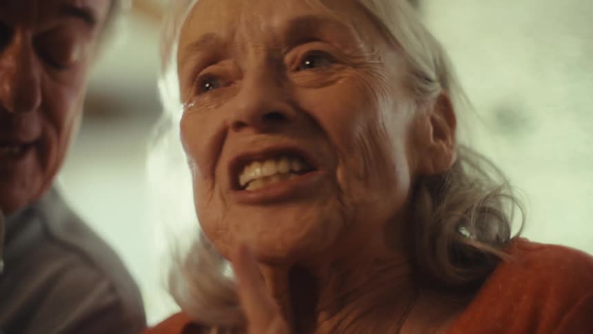 An elderly couple sings together sharing a heartfelt moment at home