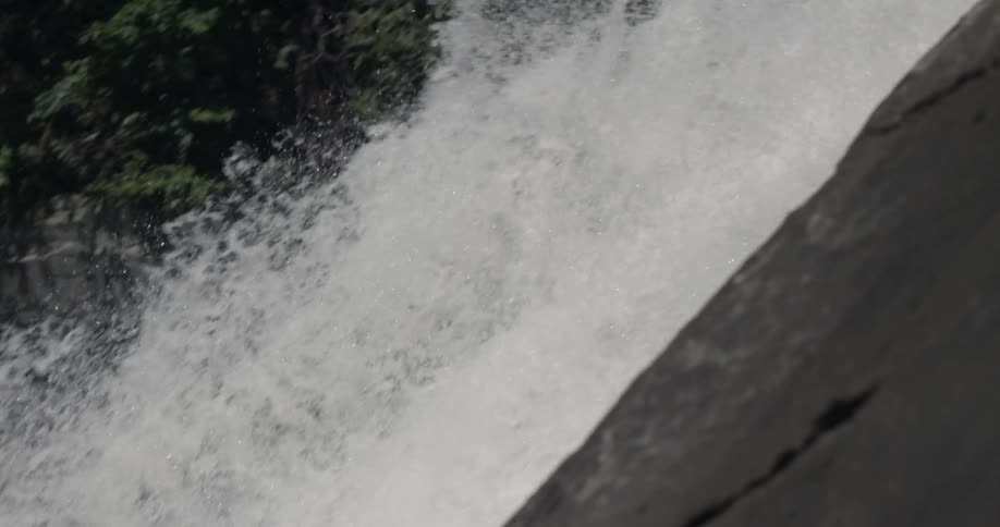The water sprays forward into the stream below