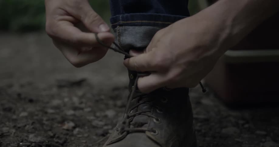 A man ties the laces on his boots