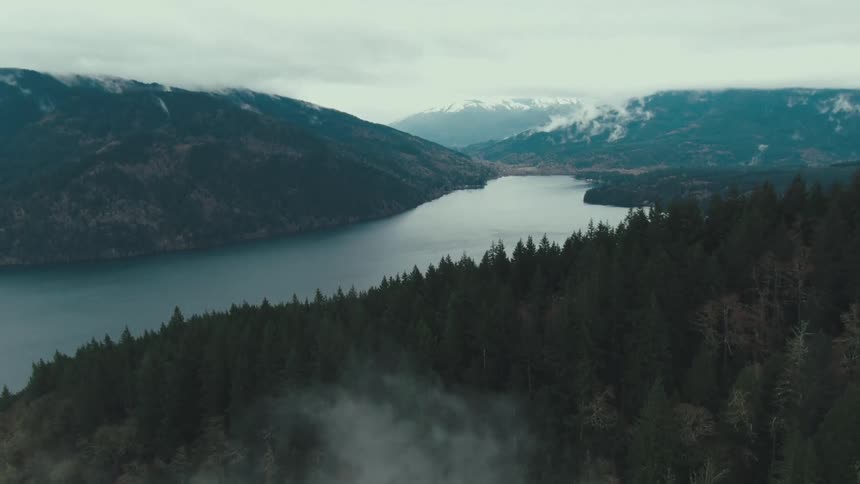 Aerial view of a mountain lake surrounded by forested hills