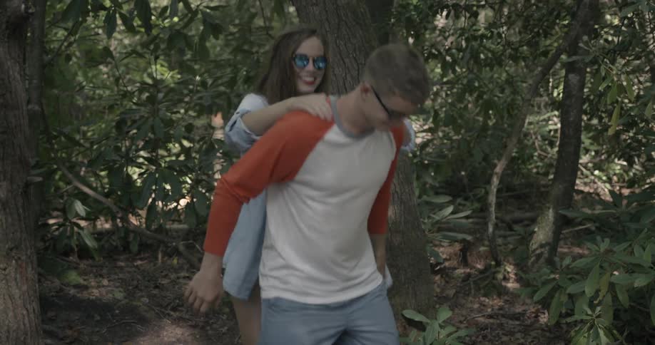 Smiling woman jumping on the back of her male friend