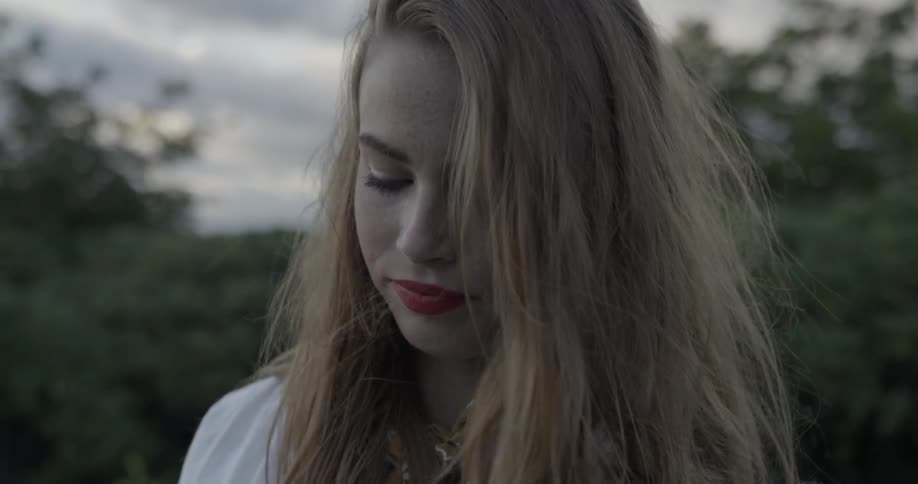 A woman's hair sways in the breeze outdoors