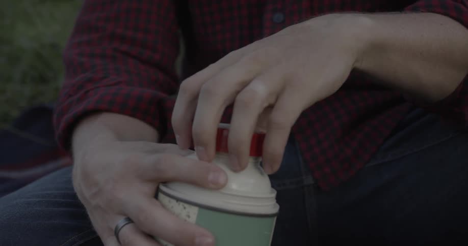 A man unscrews a thermos