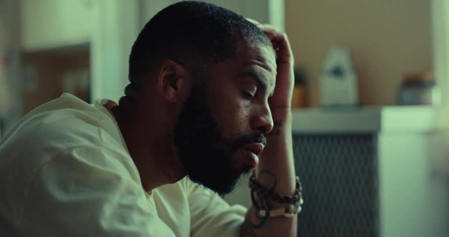 The man is sitting at home looking sad