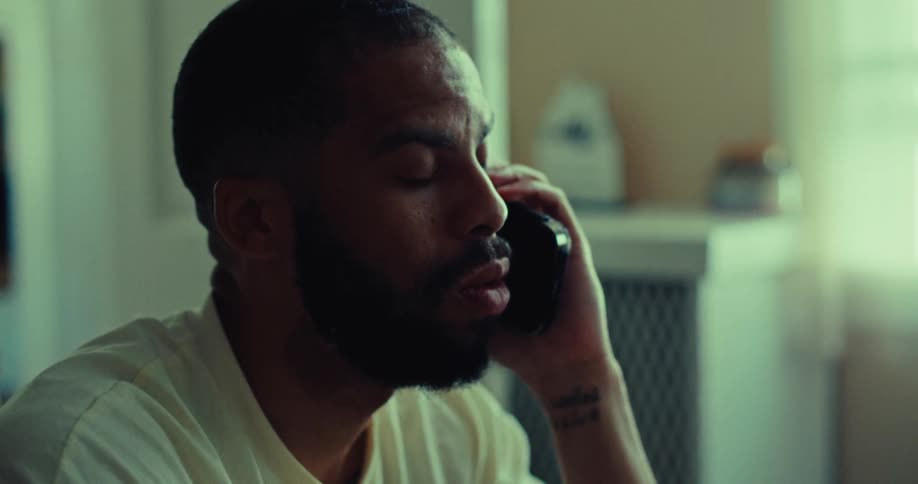 Closeup of a sad man having a phone conversation indoors