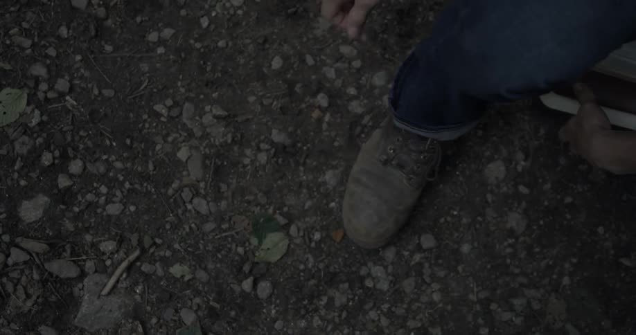 A man folds the cuff of his jean leg