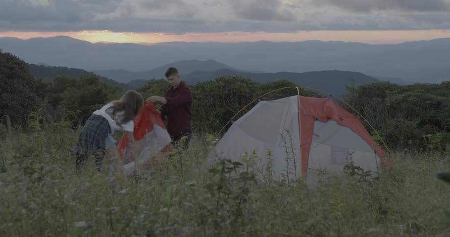 A man and woman camp outdoors