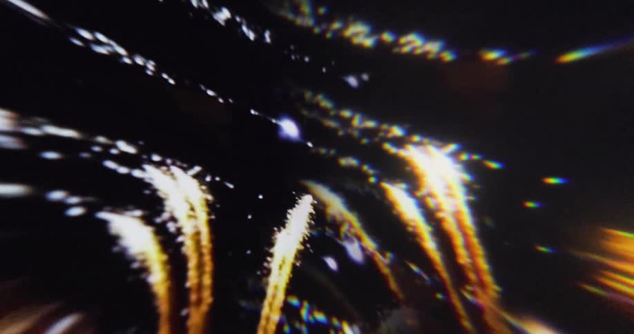Golden firework trails light up the night sky with colorful reflections