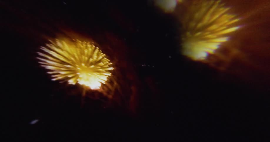 A burst of golden fireworks lights up the night sky with streaks and sparks