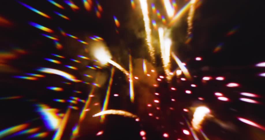 The first line of the video shows a reddishorange background with a subtle circular pattern as if seen through a glass lens the second line shows a dark background with many small colorful rainbowlike flares streaking towards the center creating a