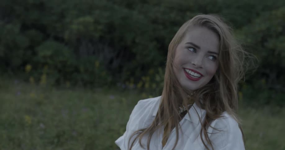 A woman smiles as her hair blows in the breeze