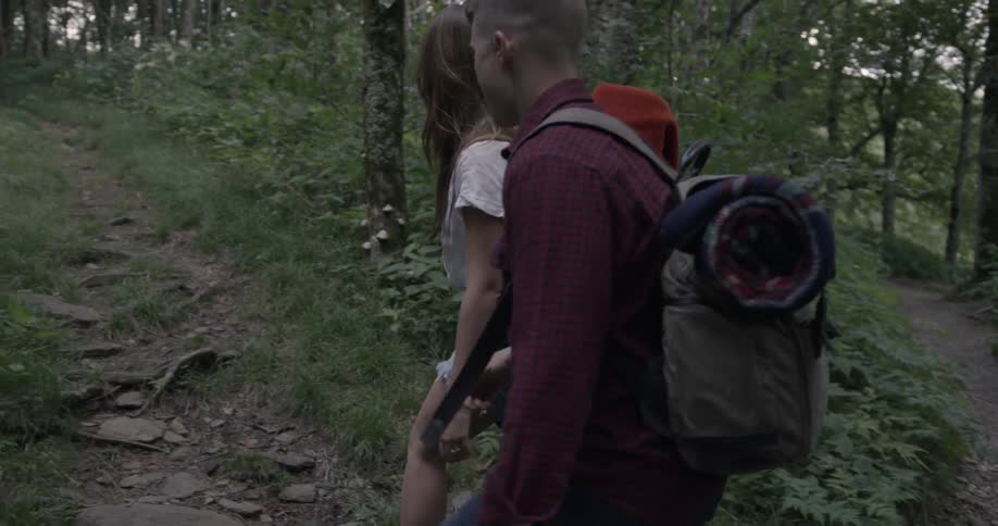Two people walk and smile around a trail