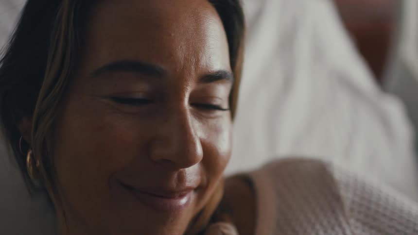A close up view of a female who is looking very happy she is wearing a earring