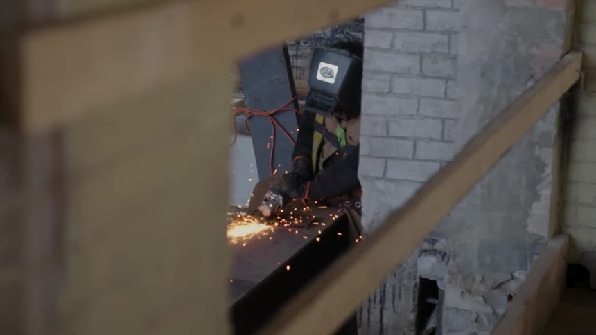 A worker is cutting metal in a workshop