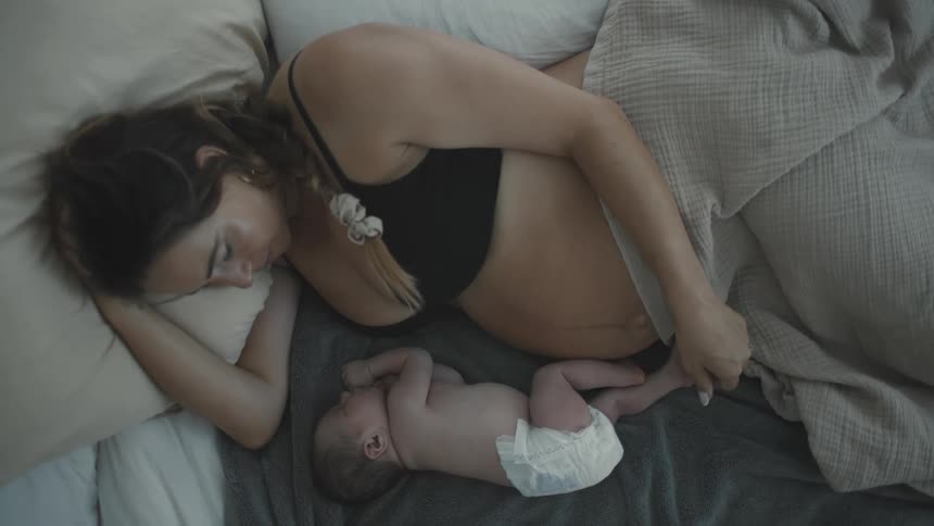 Mother lying in bed with a newborn baby