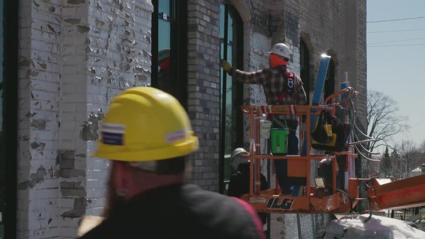 Construction workers put a new window in an old building