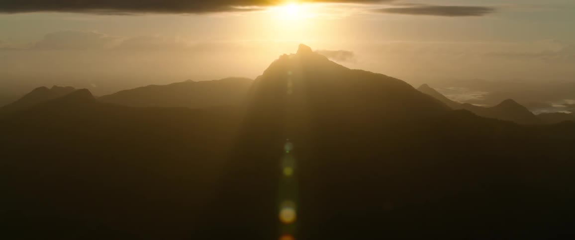 A wide aerial view of a mountain and the sun behind it makes the whole scenery more attractive