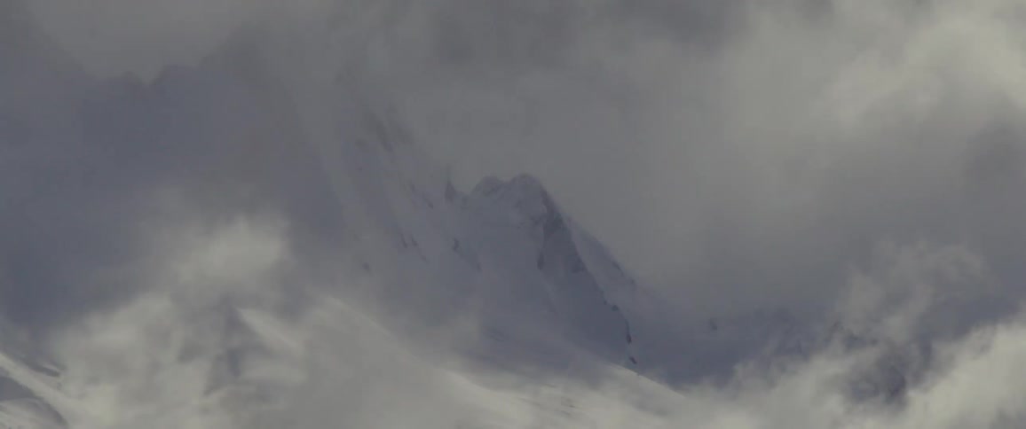 Heavy clouds sit on the snow covered mountain