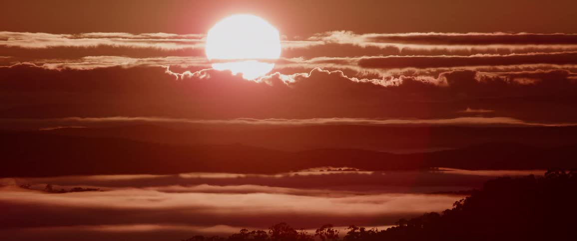 The sun is rising behind the clouds