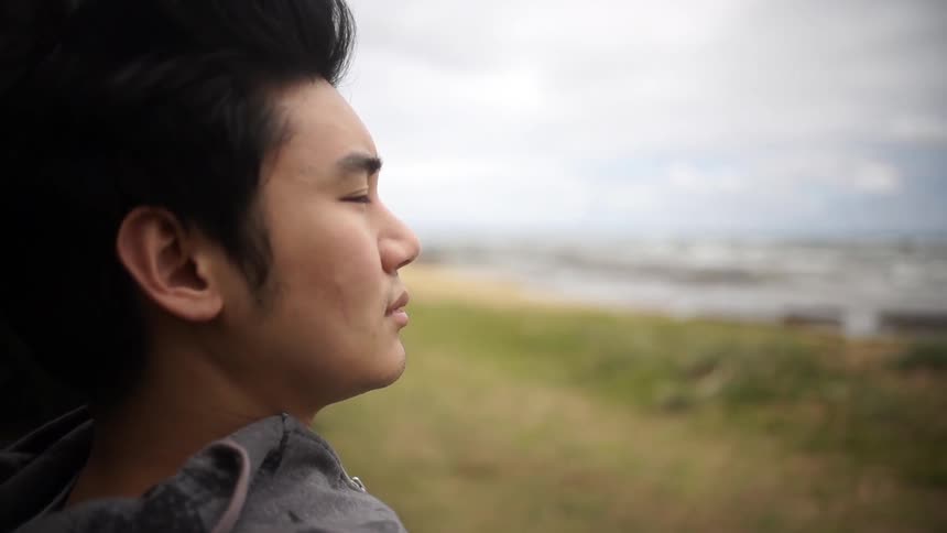 Man staring out over the coast on a cloudy day