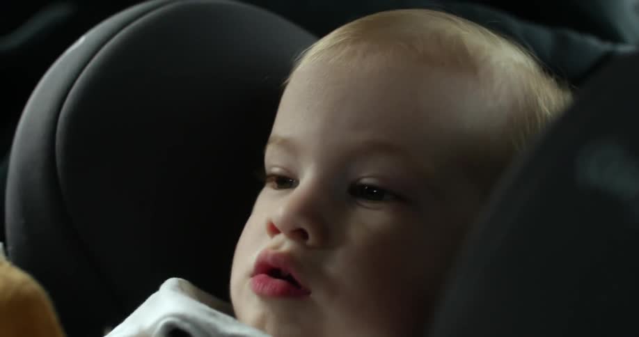 A baby sits in a car seat