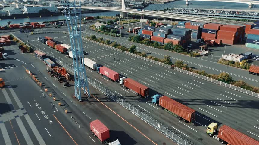 A wide aerial view of a port area and some trucks are moving cargo