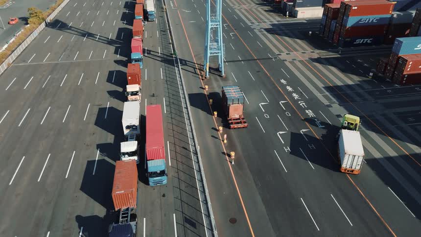 An drone shot ofa truck in a port area transportation containers
